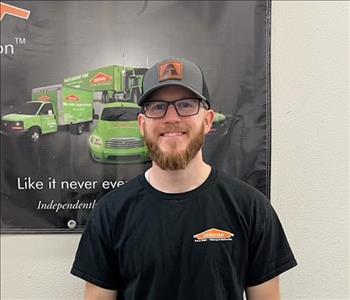 male posing in black servpro shirt and background