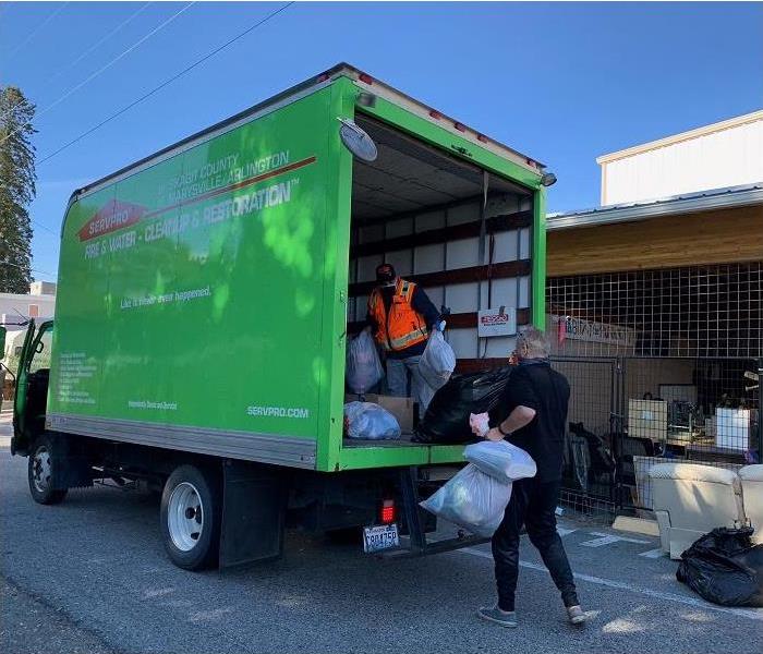 Men loading SERVPRO truck with bagged items