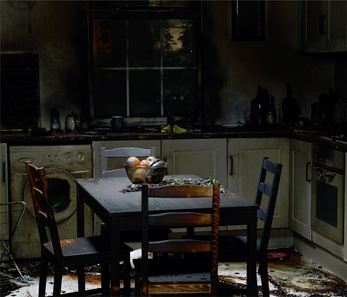 a fire damaged kitchen with soot covering the countertops and table